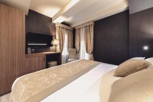 a hotel room with a bed and a television at Hotel Aquarius Venice - Ascend Collection in Venice