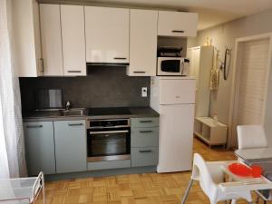 a kitchen with white cabinets and a white refrigerator at Silvo Apartments in Koper