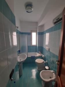 uma casa de banho com 2 WC, um lavatório e uma banheira em A DUE PASSI.... em Mazzeo