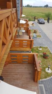 a wooden deck with a bench and a table at Ustecka Fala in Ustka