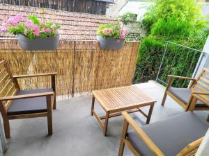 two chairs and a table on a patio with flowers at Casa Louka in Saint-Aignan