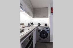eine Küche mit einer Waschmaschine und einer Waschmaschine in der Unterkunft Brand New Aprt with backyard in Lycabettus Hill ! in Athen