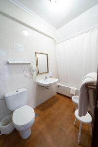 Baño blanco con aseo y lavamanos en Hotel Isabel, en Isla