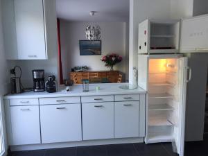 een keuken met witte kasten en een open koelkast bij Cape Cod in Wimereux
