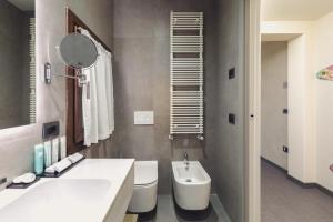 a bathroom with a sink and a toilet and a mirror at Hotel Aquarius Venice - Ascend Collection in Venice
