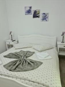 a white bed with a blanket and two night stands at Casa Artemis-jacuzzi și piscină in Pianu de Sus +30 photos