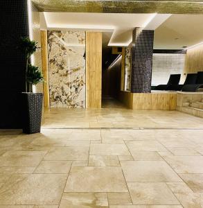 una hall con pavimento piastrellato in pietra in un edificio di JJ Sport Concept Hotel a Cracovia