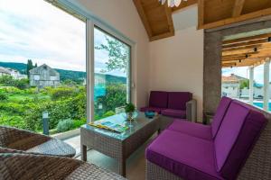 a living room with purple furniture and a large window at Villa Sarah in Lopud Island