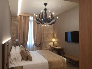a bedroom with a large bed and a chandelier at Hotel Aquarius Venice - Ascend Collection in Venice