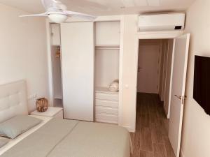 1 dormitorio con 1 cama y ventilador de techo en Playa Fontanilla Apartments, en Marbella