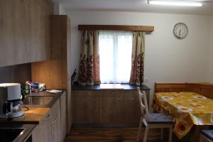 eine Küche mit einem Tisch, einem Waschbecken und einem Fenster in der Unterkunft Haus Weideli, Dammstrasse 7 in Saas-Grund
