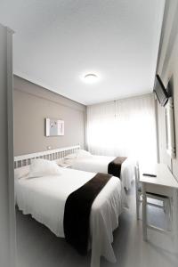 Una habitación de hotel con dos camas y un escritorio. en Hotel Isabel, en Isla 14 fotos más