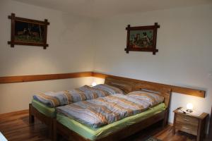 a bed in a room with two pictures on the wall at Haus Weideli, Dammstrasse 7 in Saas-Grund