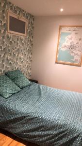 a bedroom with a bed with a blue comforter at Le Petit Caillebotis in La Rochelle