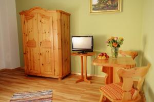 een kamer met een televisie en een bureau met een tafel en een computer bij Tutzinger Hof in Tutzing