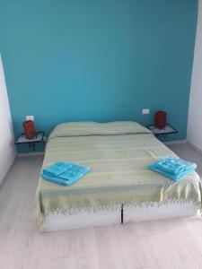 Cama en habitación con pared azul en Stromboliparadise Piscita, en Stromboli
