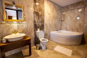 a bathroom with a tub and a toilet and a sink at Kabak Misafir Evi in Muğla