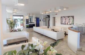 una sala de estar con muebles blancos y plantas en Hotel Diplomatic, en Riccione