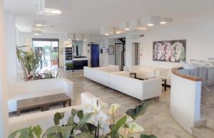 salon z białymi meblami i roślinami w obiekcie Hotel Diplomatic w mieście Riccione
