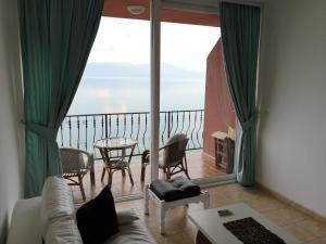 ein Wohnzimmer mit Blick auf einen Balkon in der Unterkunft Villa Eros Apartments in Struga