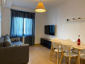 a living room with a table and a couch at Apartments Sant Lluis CENTER, 2 min walk from the sea in Lloret de Mar