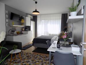 a hotel room with a bed and a table and chairs at Fészek Apartman Sopron in Sopron