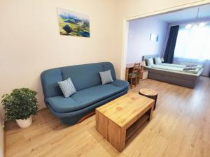 Rila Apartment في صوفيا: غرفة معيشة مع أريكة زرقاء وطاولة قهوة