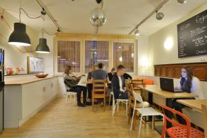 a group of people sitting at tables in a restaurant at Townside Hostel Bremen in Bremen