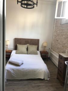 a bedroom with a large white bed with two tables at Villa des T in Arcachon