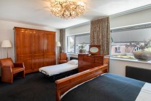 ein Schlafzimmer mit einem Bett, einer Kommode und einem Fenster in der Unterkunft Hotel La Rosa Amsterdam Beach in Zandvoort