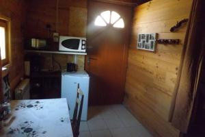 uma pequena cozinha com um frigorífico e uma janela em Petit chalet de montagne em Saint-Nectaire