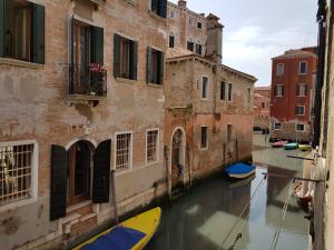 a couple of boats in a canal between two buildings at Hotel Aquarius Venice-Ascend Hotel Collection in Venice