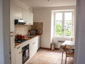 a kitchen with white cabinets and a window at Vue sur la Vezere in Treignac +21 photos
