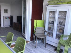 Face à la mer في سانت أي جولف: غرفة معيشة مع كراسي خضراء وطاولة