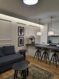 a living room with a couch and a kitchen at Apartament w sercu Zamojskiej Starówki in Zamość