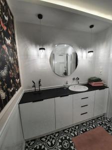 a bathroom with a sink and a mirror at Apartament w sercu Zamojskiej Starówki in Zamość