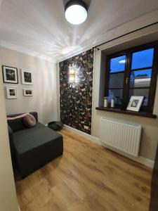 a living room with a couch and a window at Apartament w sercu Zamojskiej Starówki in Zamość