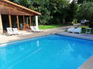 een zwembad met stoelen en een huis bij Casal dos Zimbros in Cortiços