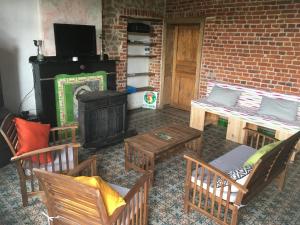 a living room with a fireplace and chairs and a stove at La Maison d'Aldegonde in Beloeil