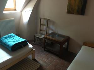 een kamer met een bed, een stoel en een tafel bij La Maison d'Aldegonde in Beloeil