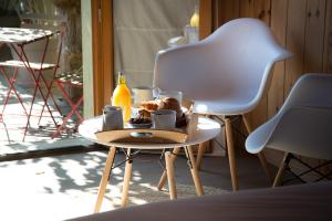 a table with a plate of food and a white chair at Centre Cap-ferret, les chambres du phare, océan in Bélisaire