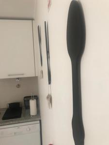 uma colher grande pendurada na parede de uma cozinha em Cabanas Apartment em Tavira