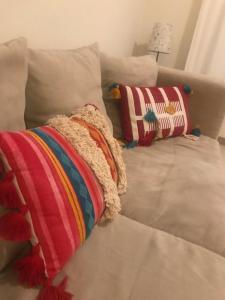 Un sofá blanco con dos almohadas. en Cabanas Apartment, en Tavira