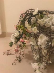 um cesto de vime cheio de flores brancas e rosas em Cabanas Apartment em Tavira