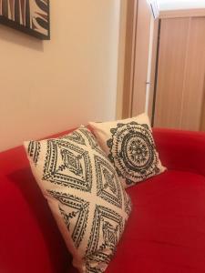 two pillows sitting on top of a red couch at Cabanas Apartment in Tavira