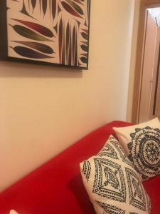 uma cama com duas almofadas e um quadro na parede em Cabanas Apartment em Tavira