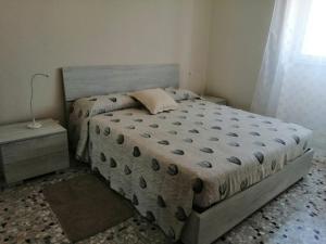 a bedroom with a large bed and a night stand at Montedarena GOLD in Pulsano
