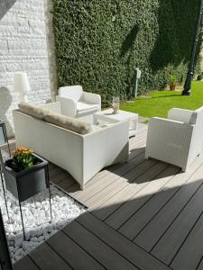 a patio with white furniture on a wooden deck at Villa Bianca in Como