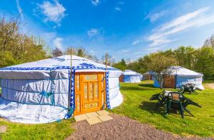 a yurt with a table and chairs in a field at la ferme des epis in Ouffières