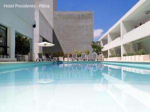 a swimming pool in front of a building at Hotel Solans Presidente in Rosario